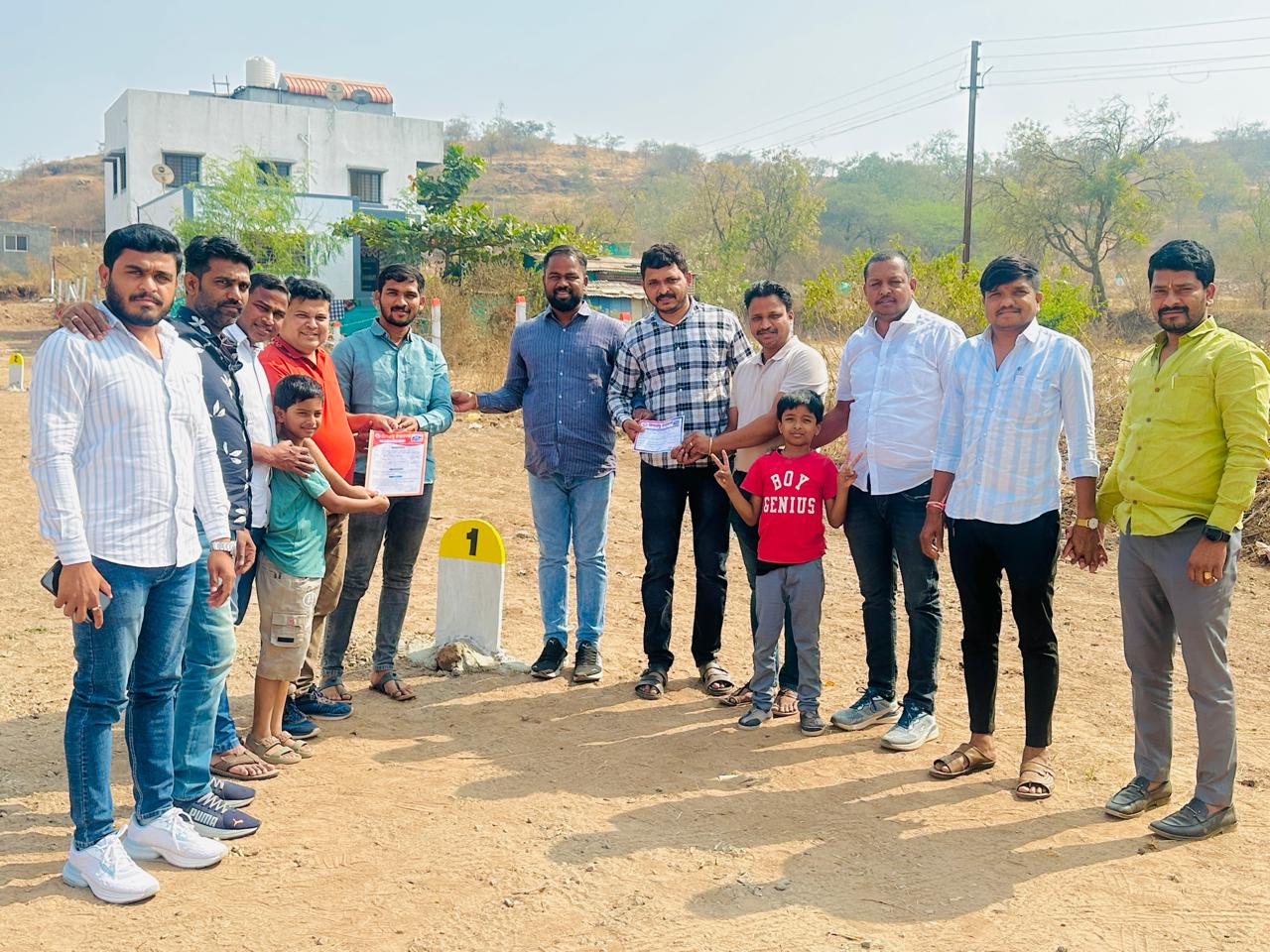 Site handover — happy buyers at Plot No. 1